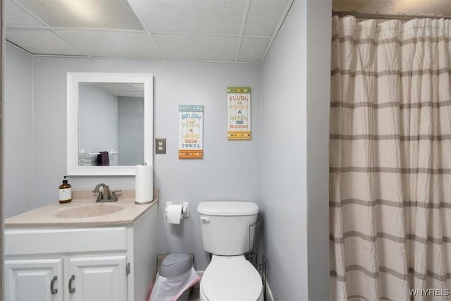 bathroom featuring vanity, a paneled ceiling, a shower with shower curtain, and toilet