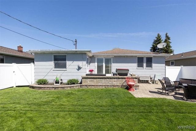 rear view of property featuring a lawn, fence, and a patio area