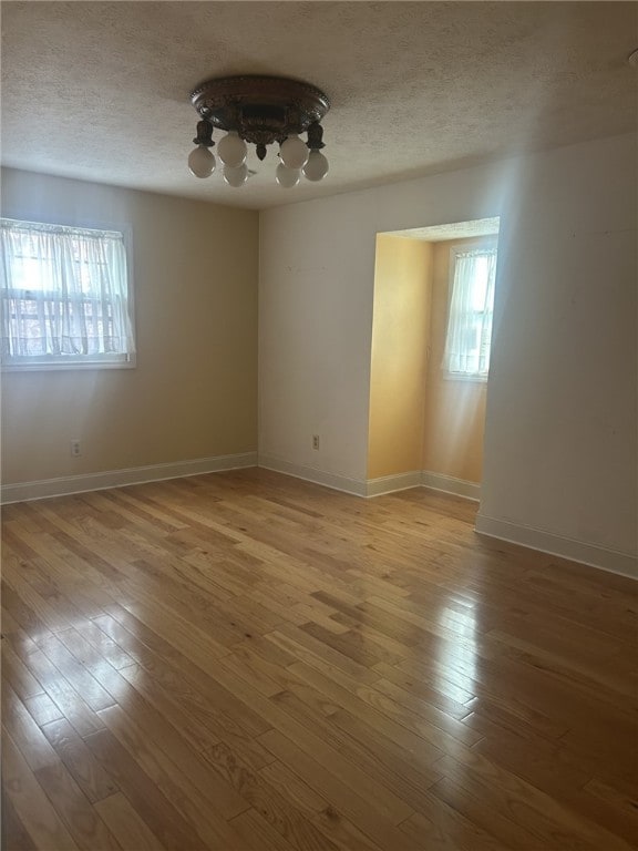 250 Schuyler Ave, Elmira-City, NY 14904 - unfurnished room with plenty of natural light, a textured ceiling, hardwood / wood-style floors, and a chandelier