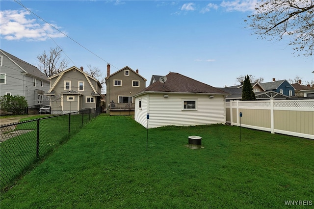 back of house with a lawn, a fenced backyard, and a residential view