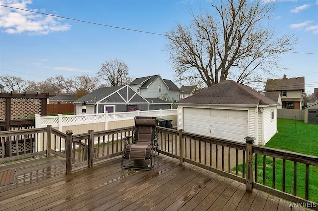 wooden deck featuring an outdoor structure, a garage, fence, a yard, and a residential view