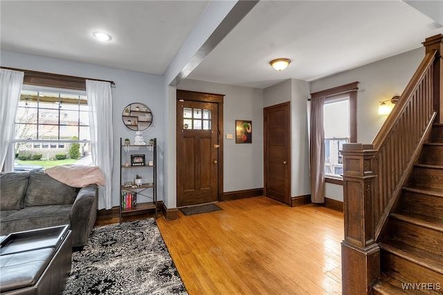 foyer entrance with recessed lighting, baseboards, light wood finished floors, and stairway