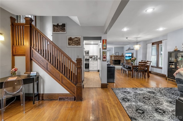 entrance foyer featuring stairs, recessed lighting, baseboards, and light wood-style floors