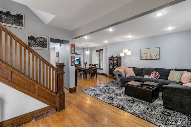 living room with visible vents, stairway, baseboards, light wood finished floors, and recessed lighting