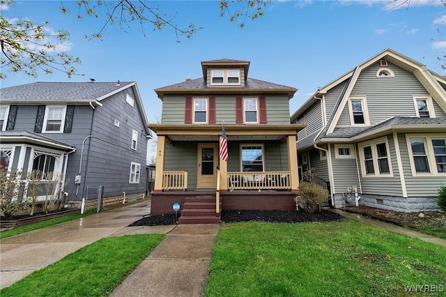 american foursquare style home featuring covered porch and a front lawn