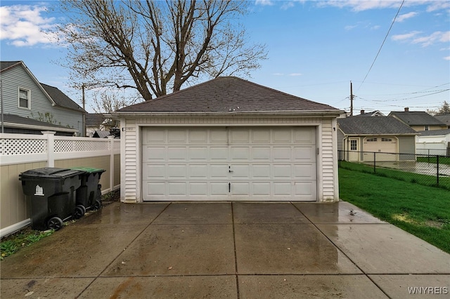 detached garage featuring fence