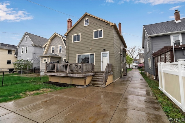 back of house with fence, a residential view, and a chimney
