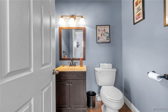 bathroom with vanity, baseboards, toilet, and wood finished floors