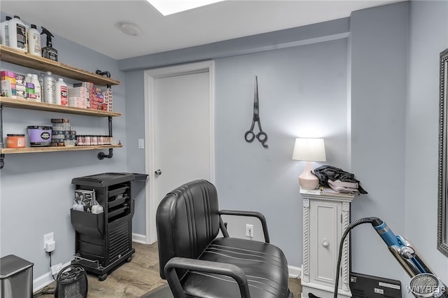 home office with baseboards, wood finished floors, and indoor bar