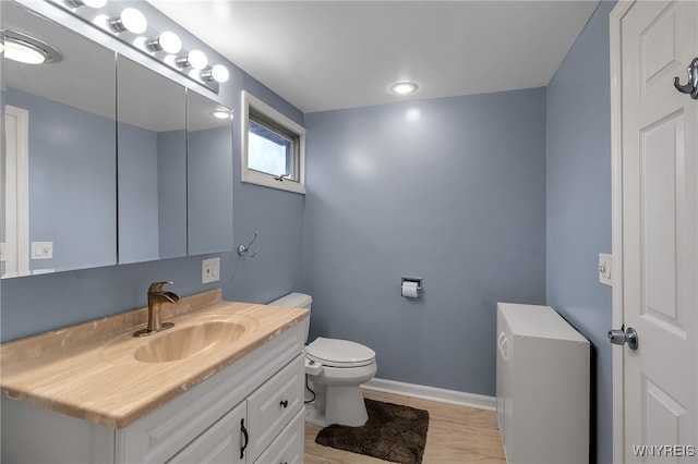 bathroom with vanity, baseboards, and toilet
