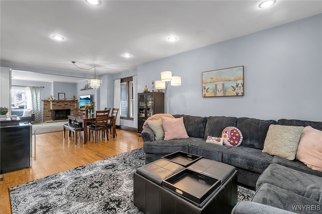 living room featuring recessed lighting, a fireplace, and light wood-type flooring