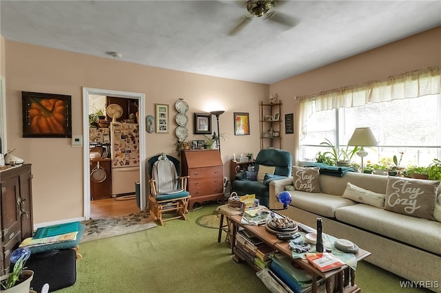 carpeted living area with ceiling fan