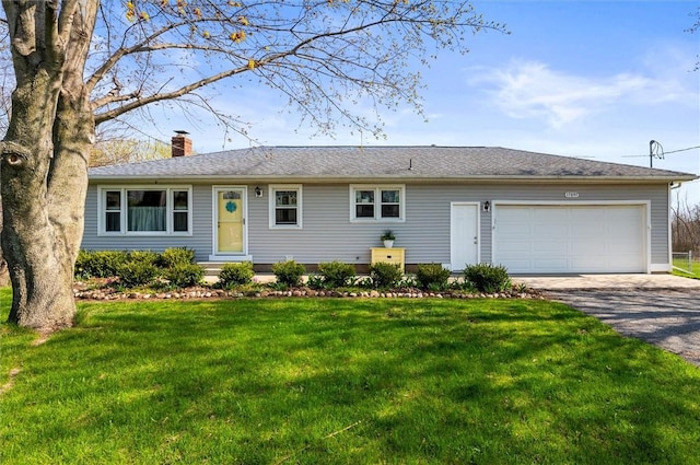 ranch-style house featuring an attached garage, a chimney, a front lawn, and aphalt driveway