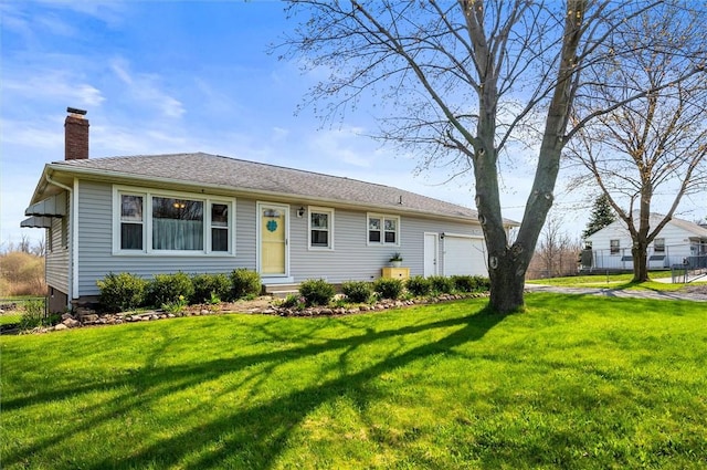 single story home featuring entry steps, a chimney, an attached garage, and a front lawn