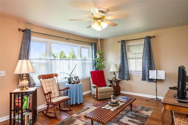 living area with a ceiling fan, baseboards, plenty of natural light, and wood finished floors