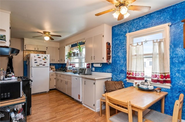 kitchen with a ceiling fan, light countertops, under cabinet range hood, white appliances, and light wood-style flooring
