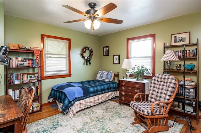 bedroom featuring multiple windows and wood finished floors