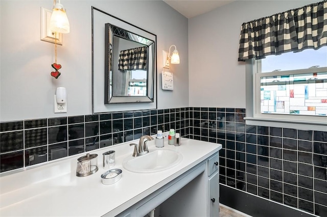 bathroom featuring vanity, wainscoting, and tile walls