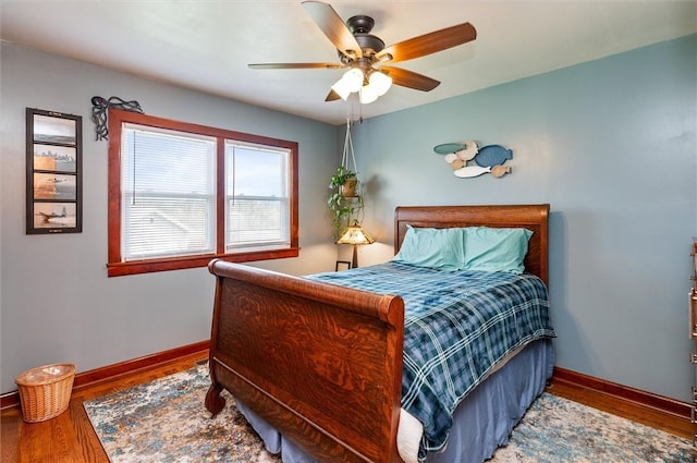 bedroom with a ceiling fan, baseboards, and wood finished floors