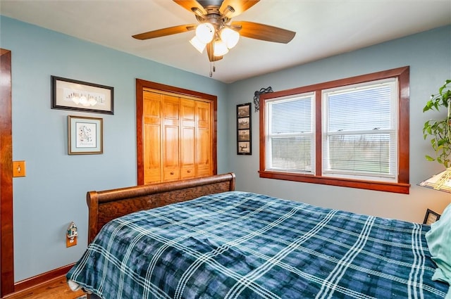 bedroom featuring baseboards, ceiling fan, a closet, and wood finished floors