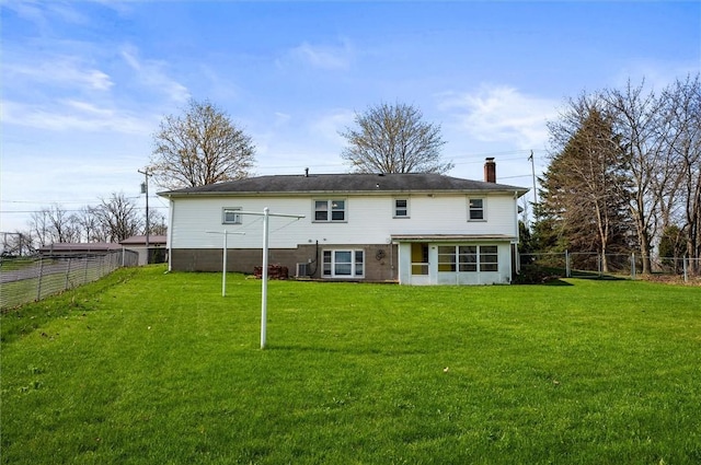 rear view of house with a lawn, a fenced backyard, and a chimney