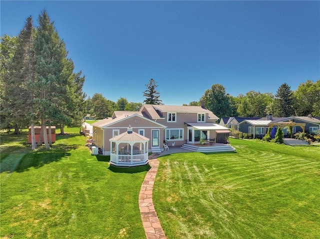 back of house featuring a wooden deck, a gazebo, and a yard