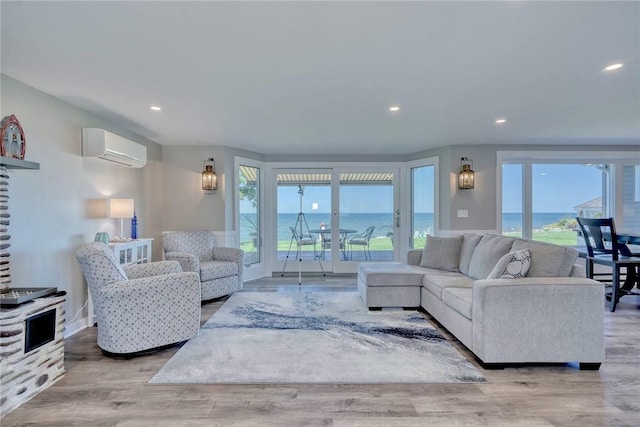 living room with recessed lighting, a wall mounted AC, wood finished floors, and a water view