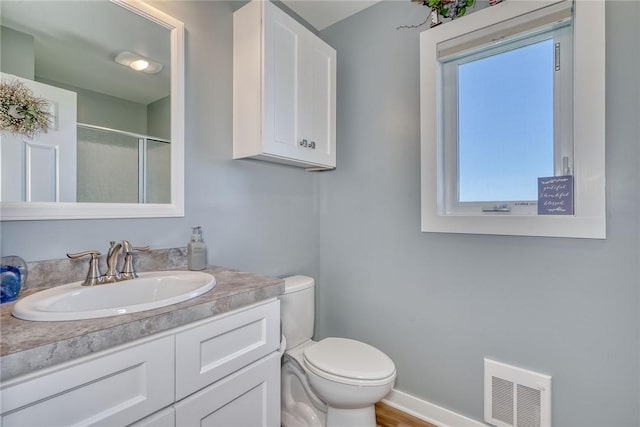 bathroom with visible vents, a stall shower, vanity, baseboards, and toilet