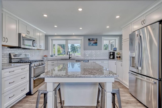 kitchen featuring a breakfast bar area, recessed lighting, tasteful backsplash, a sink, and stainless steel appliances