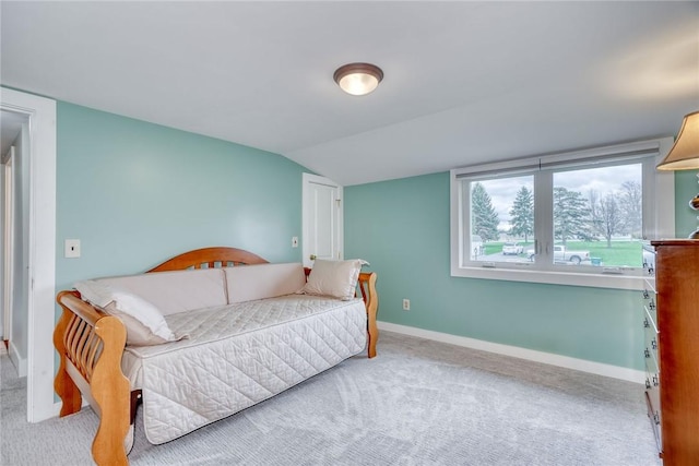carpeted bedroom with baseboards and lofted ceiling