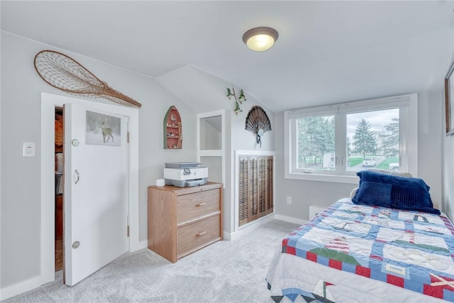 bedroom with baseboards, light carpet, and lofted ceiling