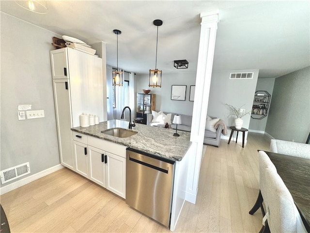 kitchen featuring stainless steel dishwasher, a sink, visible vents, and light wood-type flooring