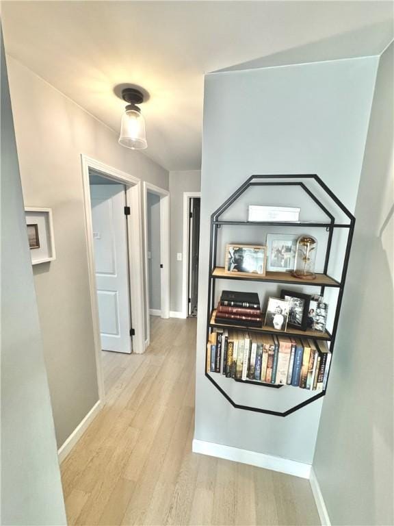 hallway featuring baseboards and light wood finished floors