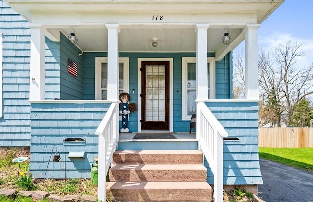 entrance to property with fence and covered porch