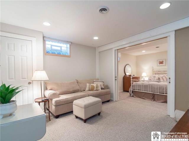 living area featuring carpet floors, recessed lighting, and visible vents