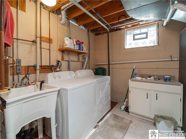 washroom featuring laundry area, a sink, and separate washer and dryer