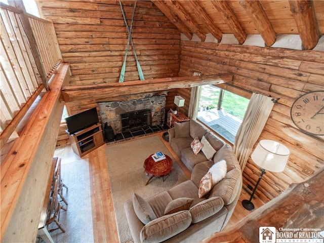 living room with a fireplace, wood finished floors, wooden ceiling, beamed ceiling, and log walls