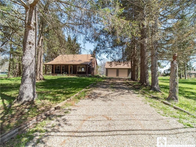 view of front facade featuring a porch, driveway, an outbuilding, and a front yard