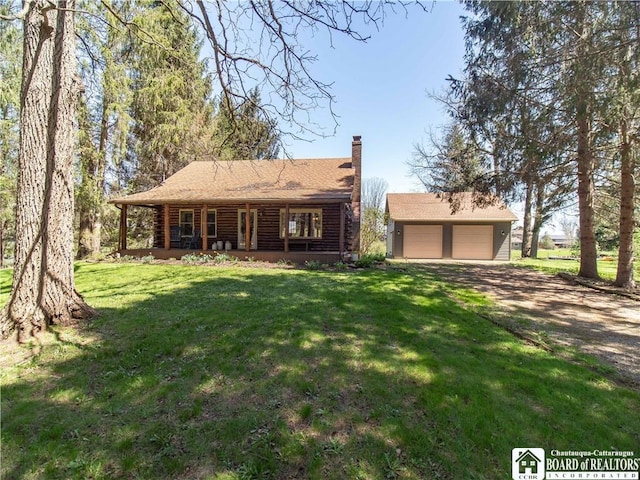 view of front of property featuring covered porch, a garage, log exterior, an outdoor structure, and a front lawn