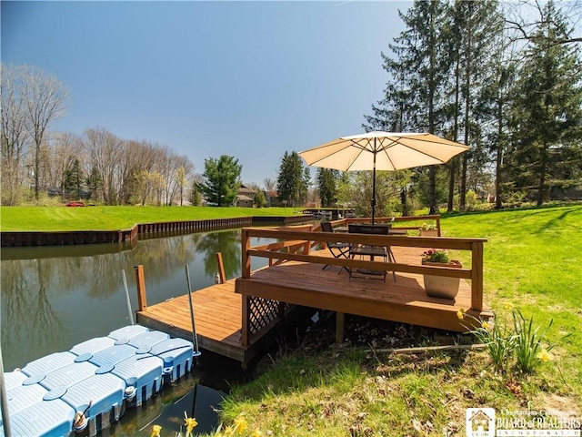 view of dock featuring a water view and a yard