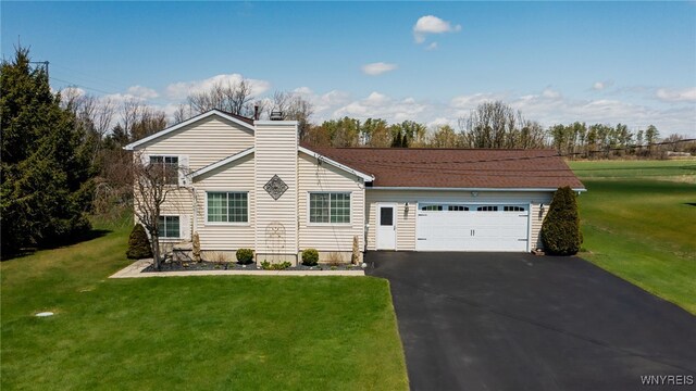view of front of property featuring an attached garage, a chimney, a front lawn, and aphalt driveway