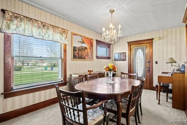 dining area featuring carpet floors, wallpapered walls, and a chandelier