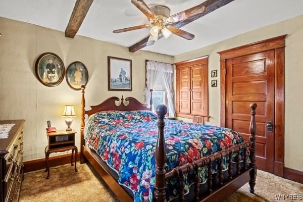 bedroom featuring baseboards, beamed ceiling, a ceiling fan, and wood finished floors