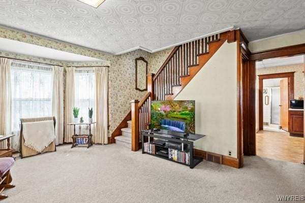 carpeted living area with visible vents, stairs, baseboards, an ornate ceiling, and wallpapered walls