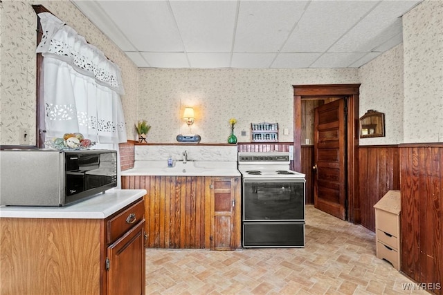 404 72nd St, Niagara Falls, NY 14304 - kitchen with electric stove, wallpapered walls, a drop ceiling, a wainscoted wall, and light countertops