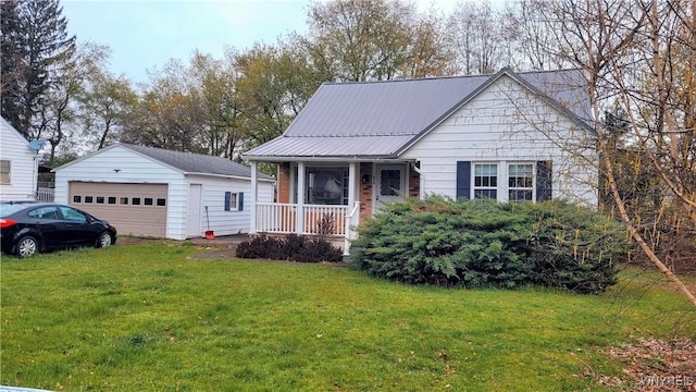 ranch-style home with an outbuilding, a front lawn, covered porch, and a detached garage
