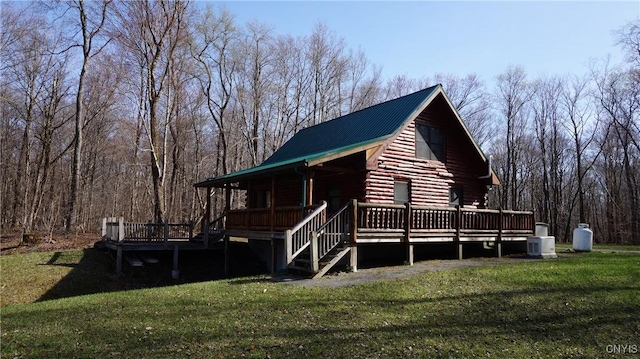 exterior space with log exterior, metal roof, and a front lawn