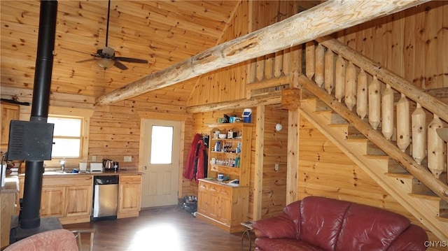 living area featuring a wood stove, stairs, wood walls, lofted ceiling, and dark wood-type flooring