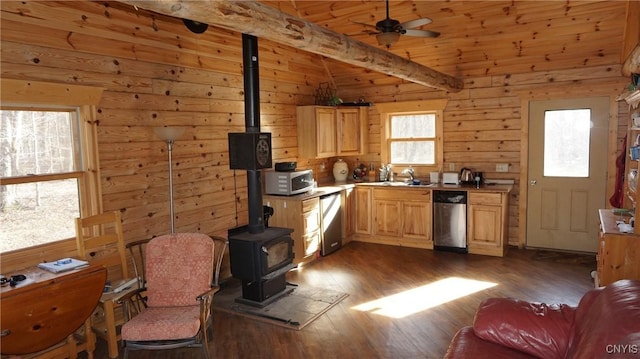 kitchen with a wood stove, light brown cabinets, dark wood-type flooring, a ceiling fan, and dishwasher