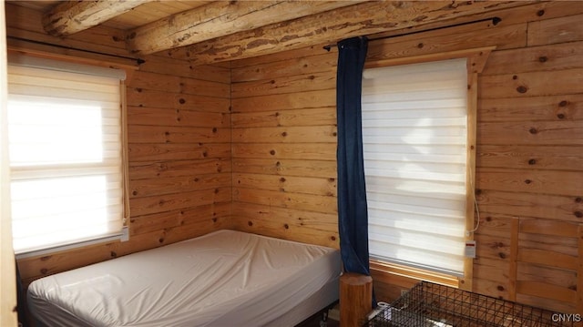 bedroom featuring wooden walls, wooden ceiling, and beamed ceiling